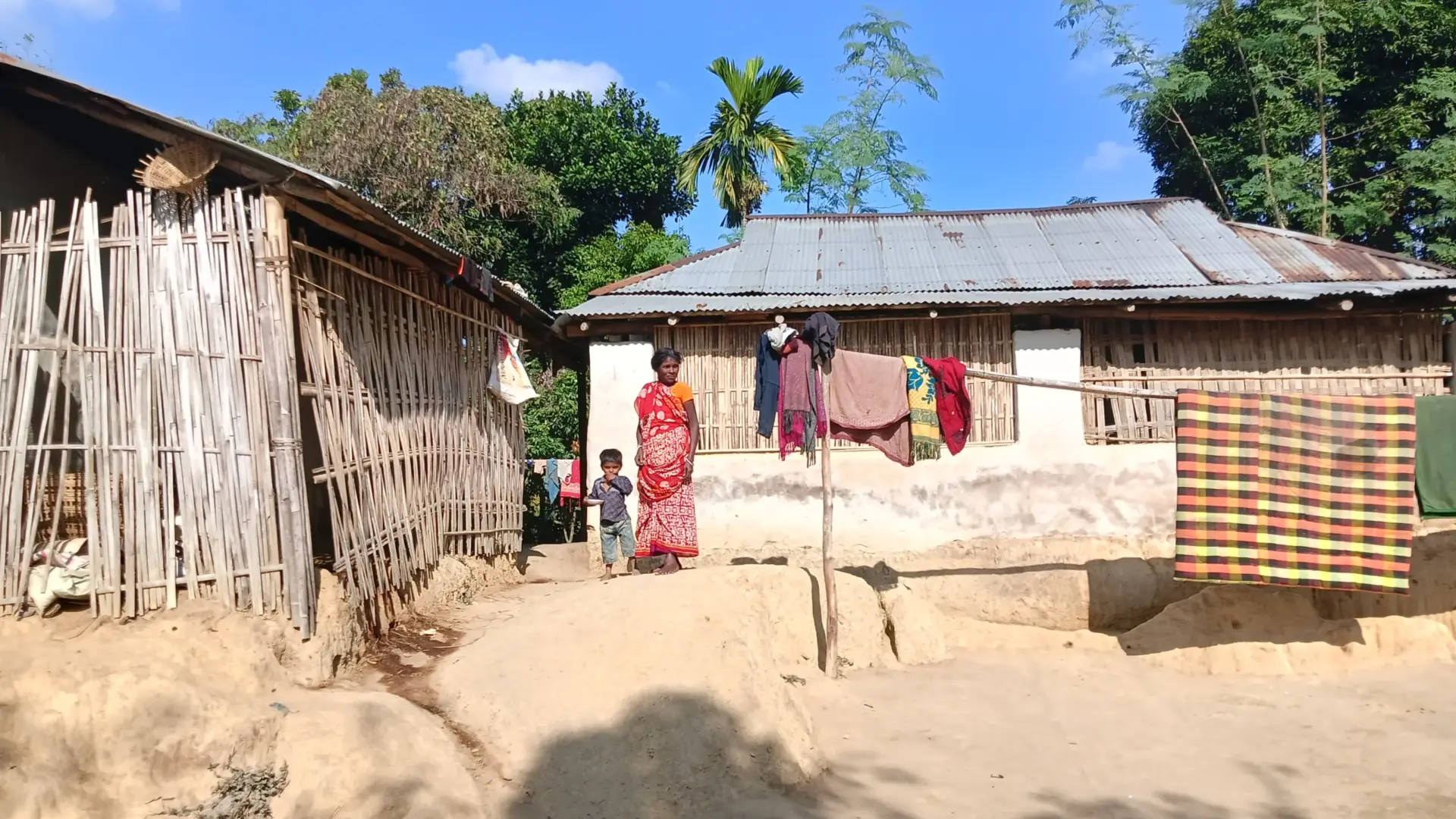 A child with his mother outside his house