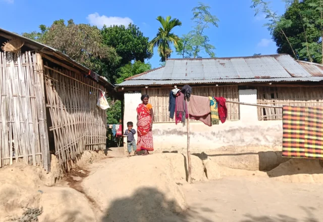 A child with his mother outside his house