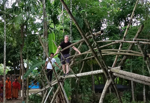 A tourist crossing a bamboo bridge