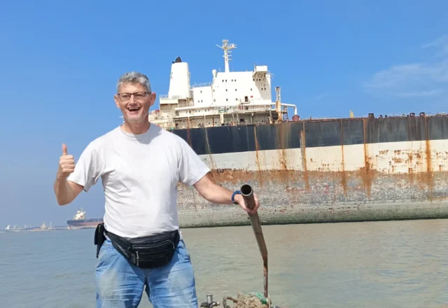 A tourist taking a shot with a ship behind the back