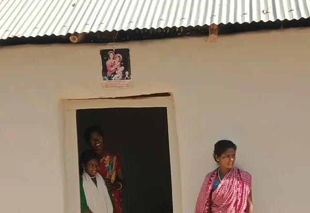 Beautiful smiling girls at the door of their house with their mother
