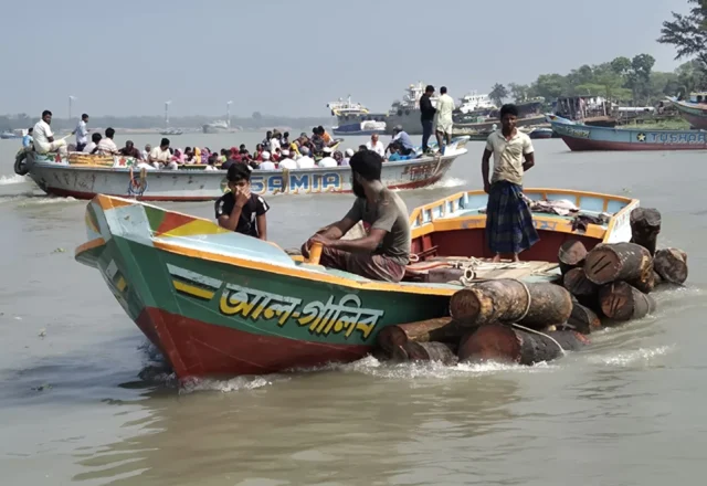 Labourers carrying timber by boat