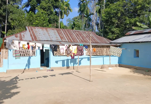 Locals drying clothes on a rope in front of the house
