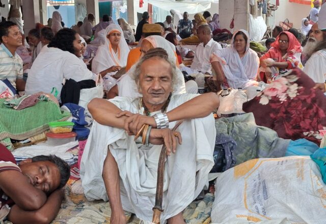 Baul devotees in white resting in the hall at Lalon Akhra