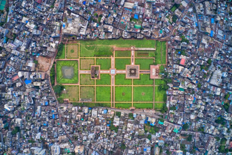 Aerial view of Lalbagh Fort's green Mughal gardens surrounded by the dense rooftops of Old Dhaka