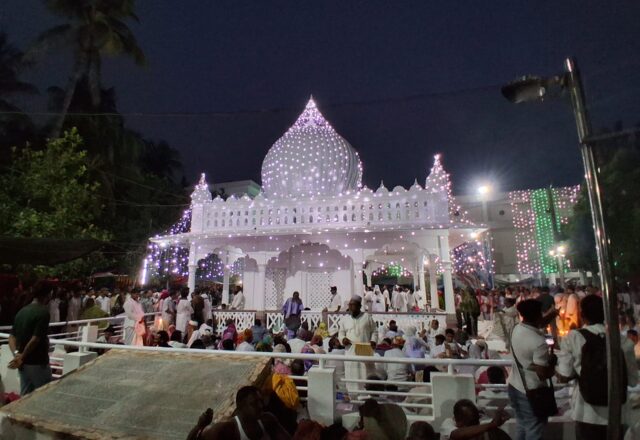 Devotees gather in the courtyard of Lalon Shah's illuminated shrine at night