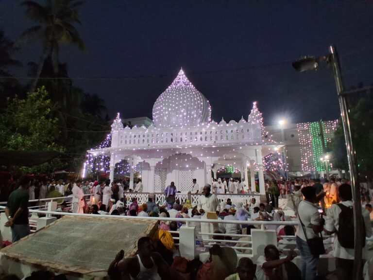 Devotees gather in the courtyard of Lalon Shah's illuminated shrine at night